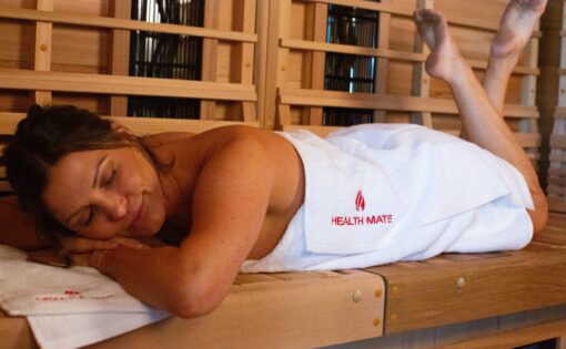 Woman relaxes and detoxes in her Health Mate Infrared Sauna