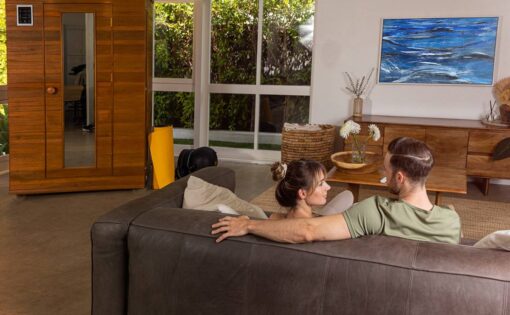 young couple sitting on couch with new sauna