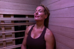 woman sweating in infrared sauna with incoloy heaters
