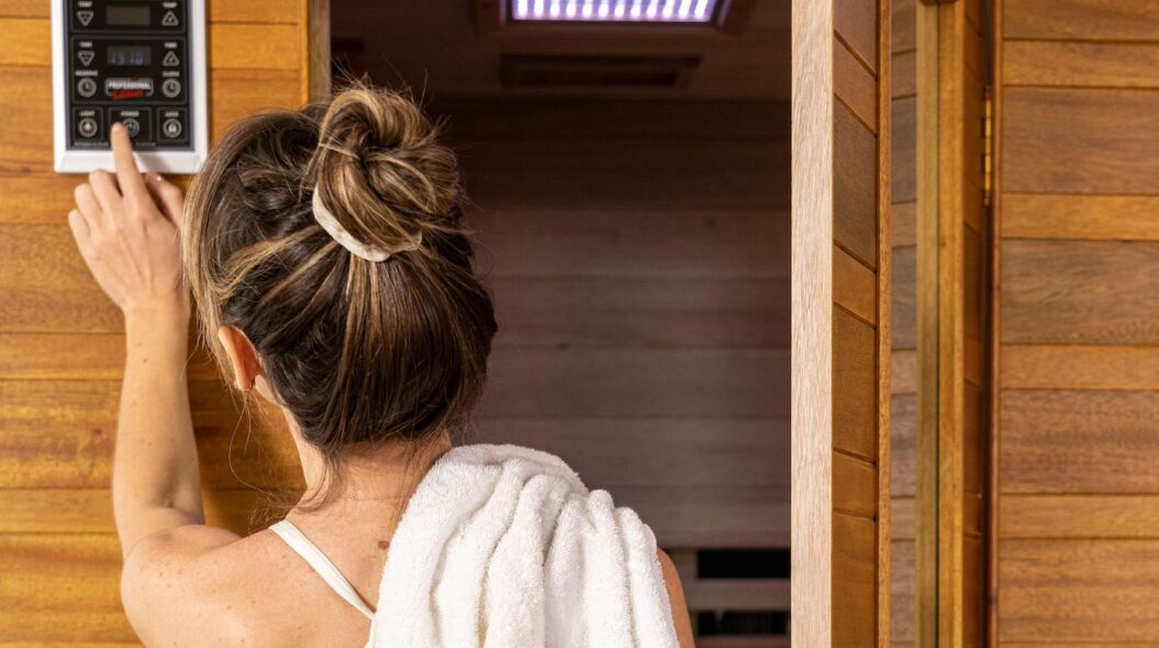 woman with her back to us turning on her health mate infrared sauna