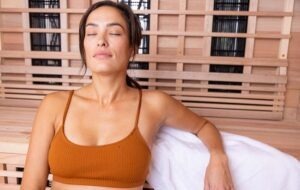 woman spending downtime in infrared sauna relaxing