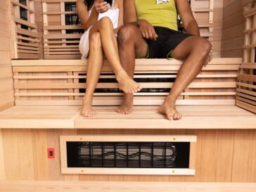 a couple from the waist down sitting in their infrared sauna