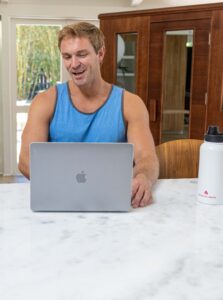 Man using laptop with home sauna in background